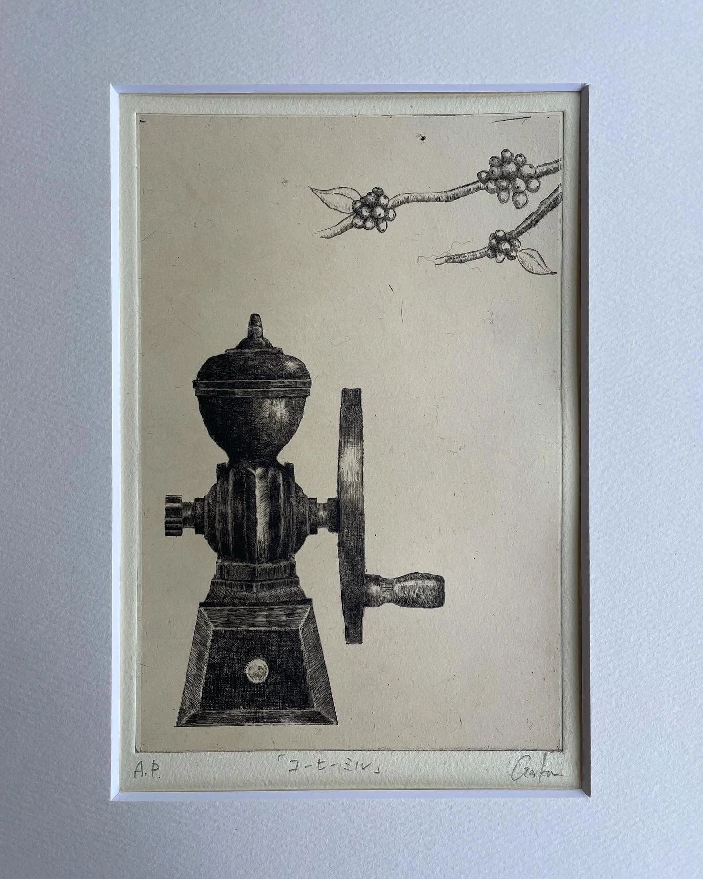 額に収めた、コーヒーミルと実のついた枝を細かな黒い線で描いた作品
